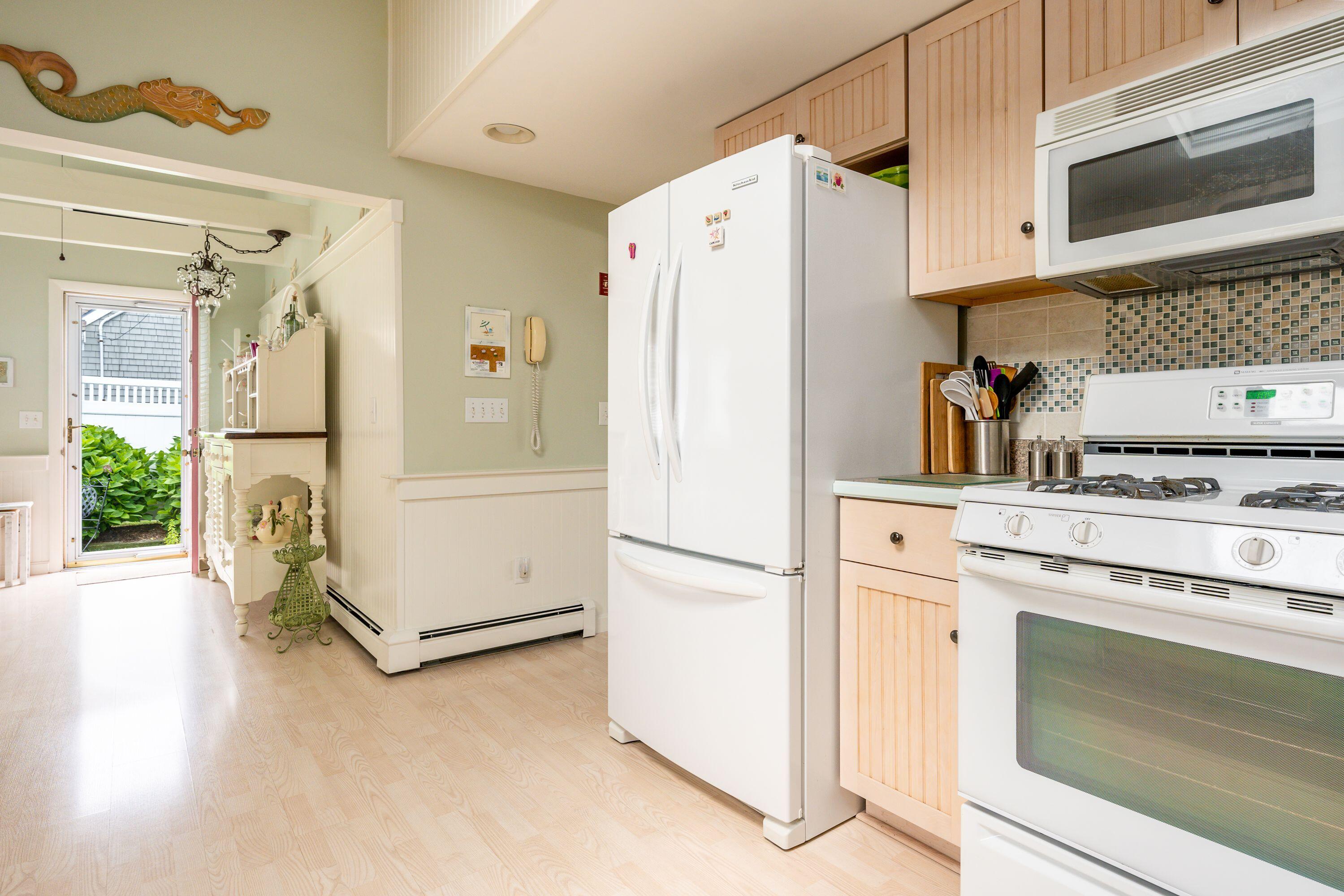 85 Surfside Road West Dennis, MA 02670 - Photo 11 of 34 a kitchen with a refrigerator stove and white cabinets