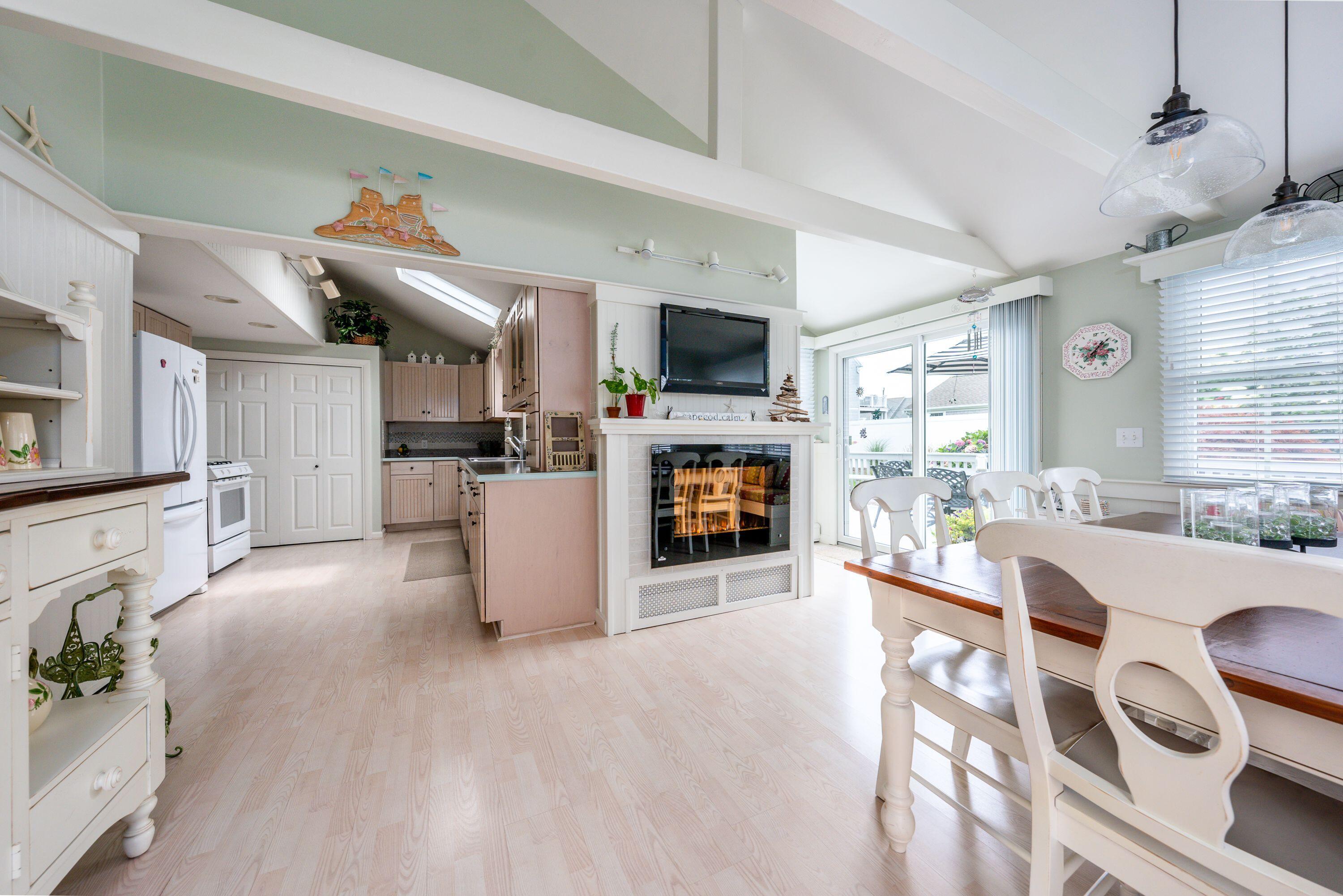 85 Surfside Road West Dennis, MA 02670 - Photo 5 of 34 a living room with furniture a flat screen tv and a kitchen view