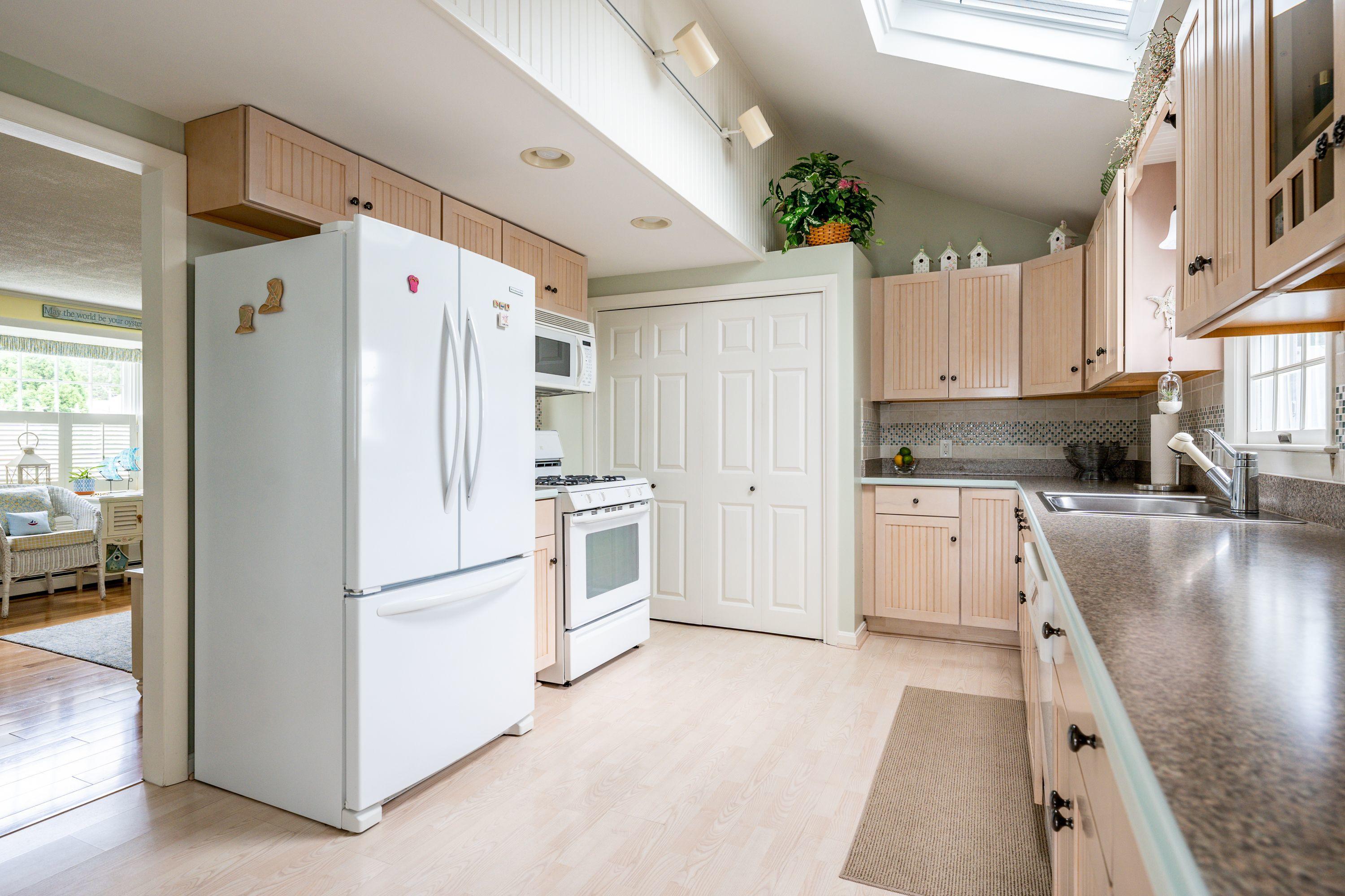 85 Surfside Road West Dennis, MA 02670 - Photo 10 of 34 a kitchen with white cabinets and white appliances