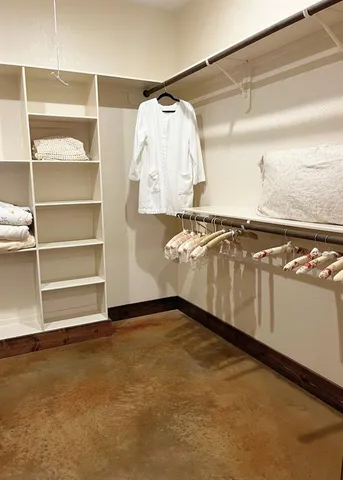 a view of walk in closet with clothes and shoes