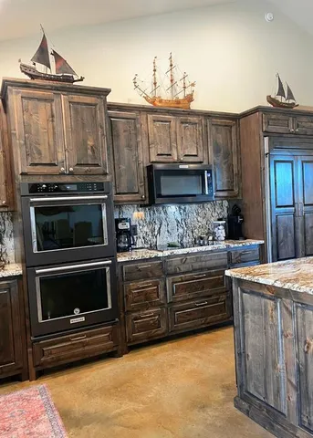 a kitchen with stainless steel appliances granite countertop a stove and a microwave
