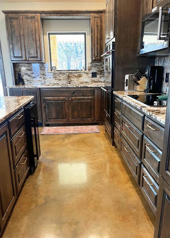 6601 Rash Court Granbury, TX 76049 - Photo 10 of 23 a large kitchen with stainless steel appliances granite countertop a sink and cabinets