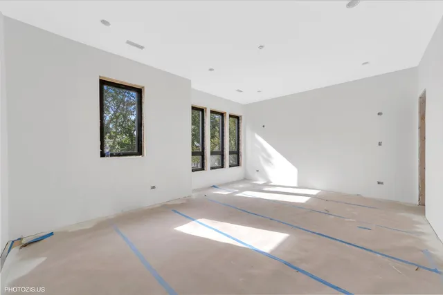 a view of an empty room with stairs and a window