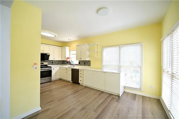 a view of a large kitchen with wooden floor and a window