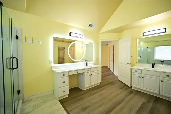 a bathroom with a shower sink vanity mirror and toilet