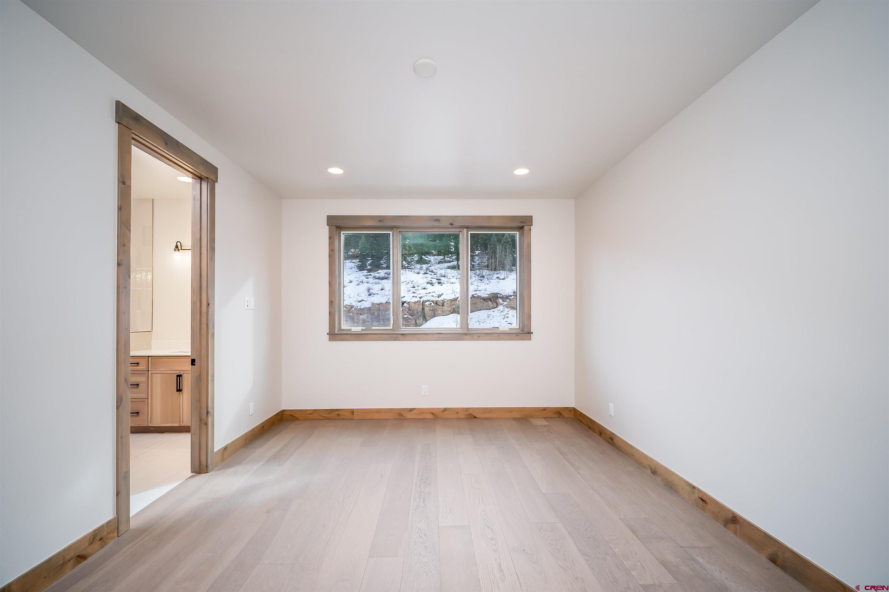 93 Travertine Trail Durango, CO 81301 - Photo 12 of 44 an empty room with wooden floor and windows