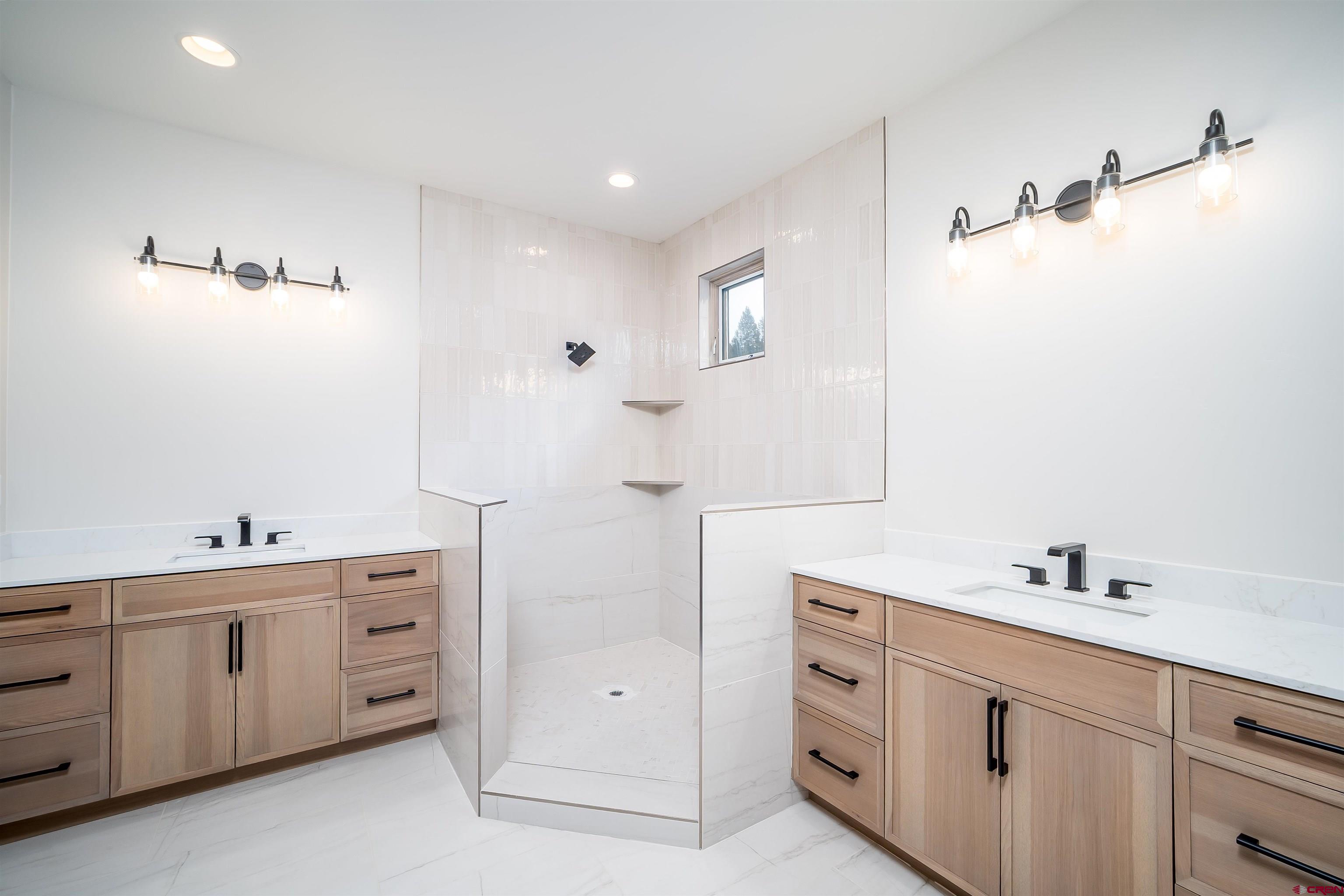 93 Travertine Trail Durango, CO 81301 - Photo 3 of 44 a spacious bathroom with a double vanity sink a mirror and a bathtub