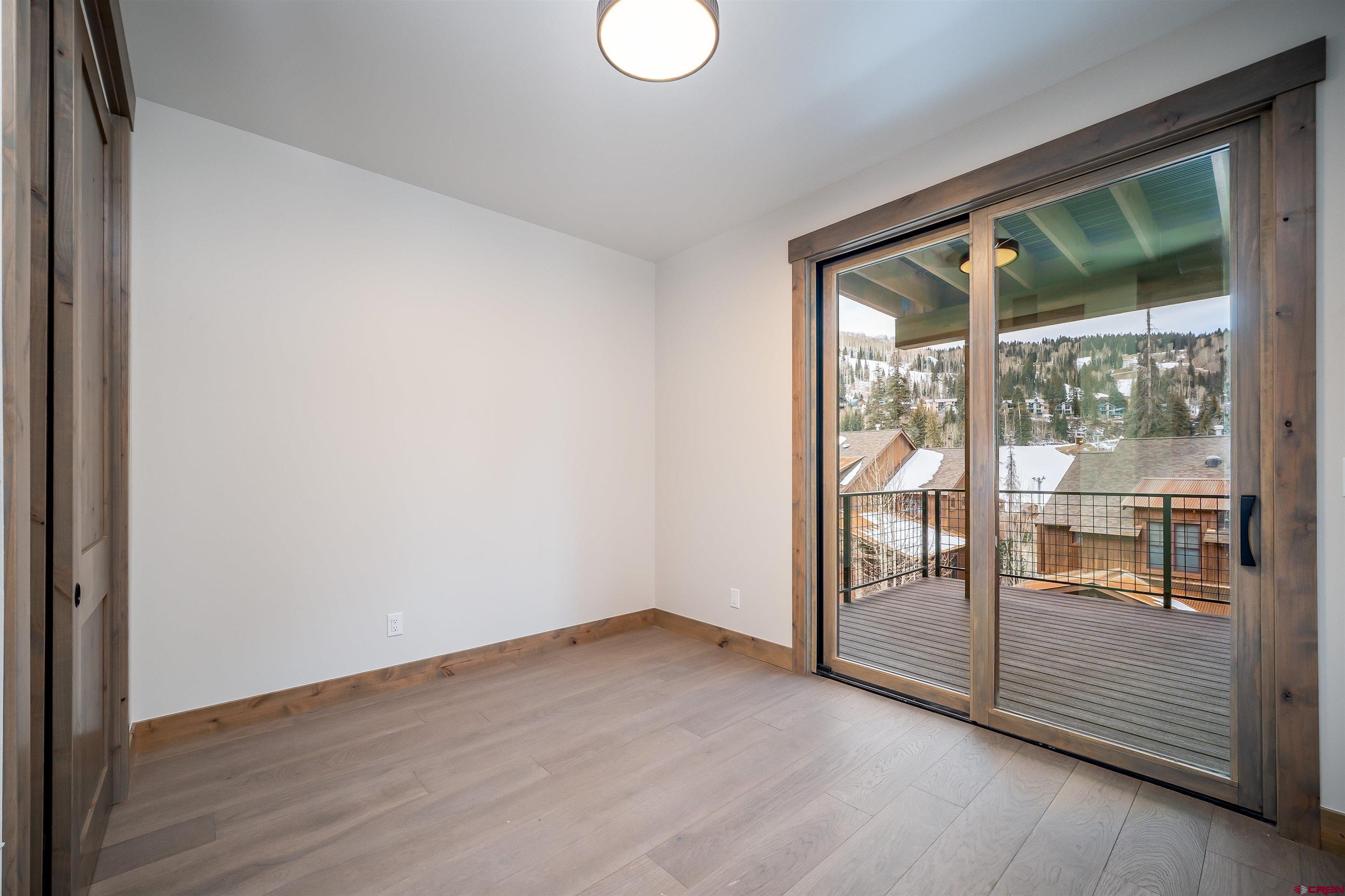 93 Travertine Trail Durango, CO 81301 - Photo 6 of 44 an empty room with wooden floor and windows