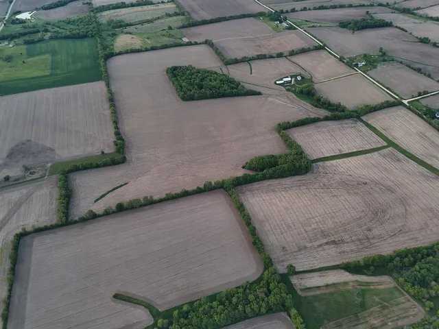 an aerial view of a house with a yard and tennis court