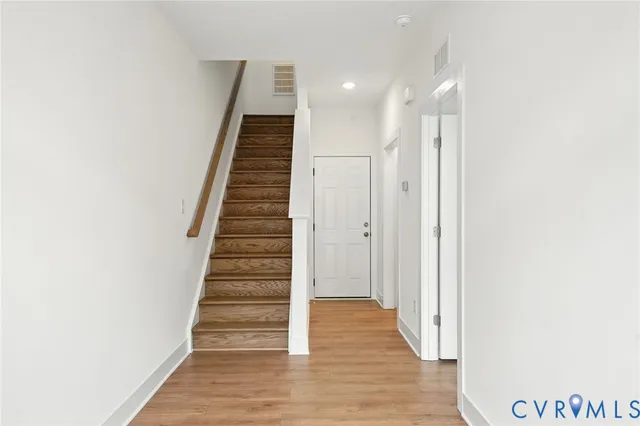 a view of a hallway with wooden floor and entryway