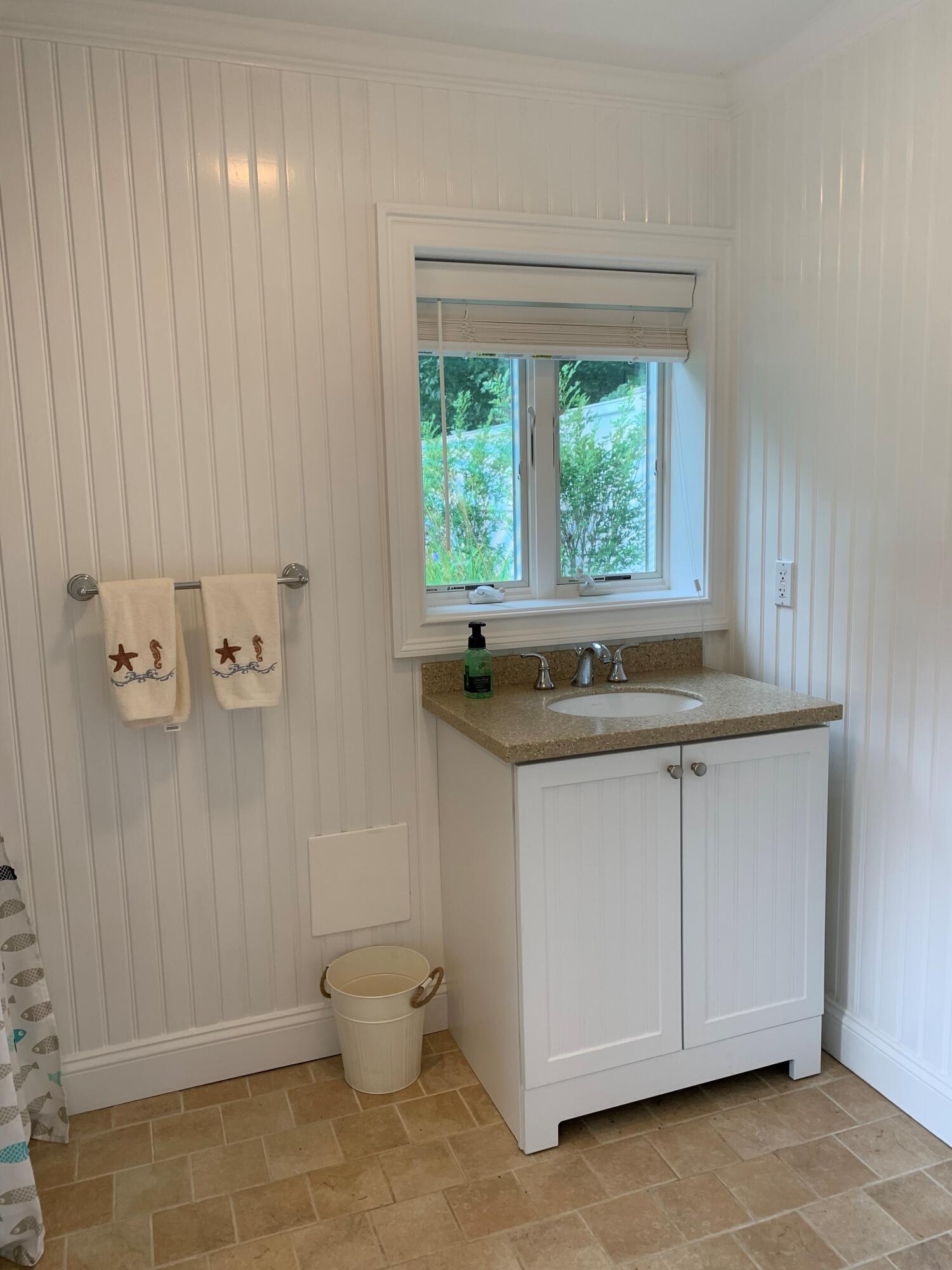 1490 South County Road Osterville, MA 02655 - Photo 74 of 75 a bathroom with a granite countertop sink a toilet and a window