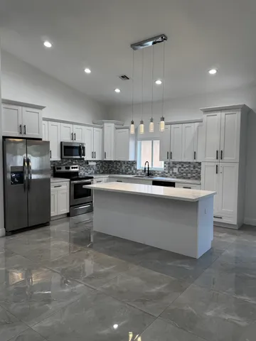 a large kitchen with stainless steel appliances lots of counter space