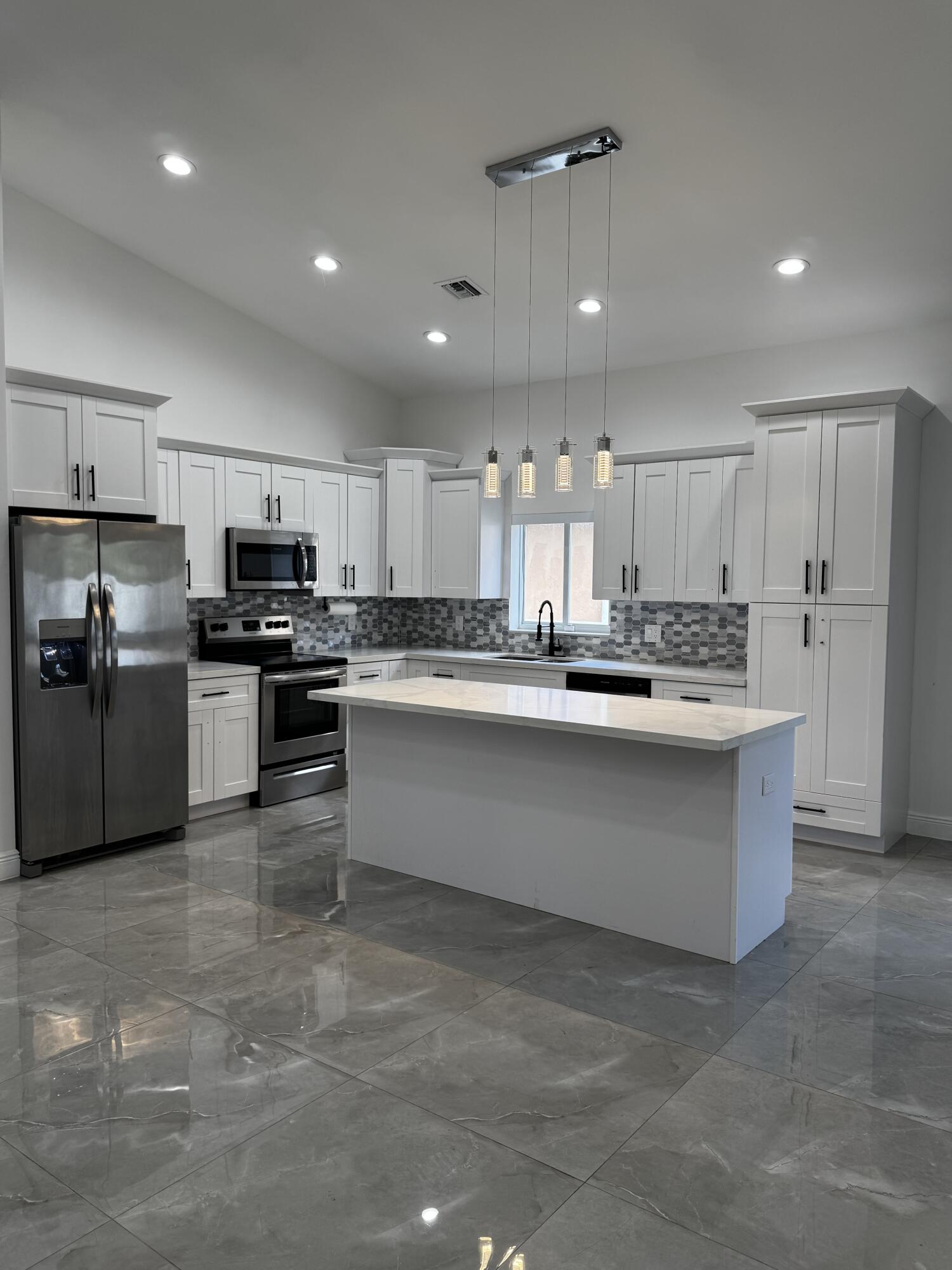 a large kitchen with stainless steel appliances lots of counter space