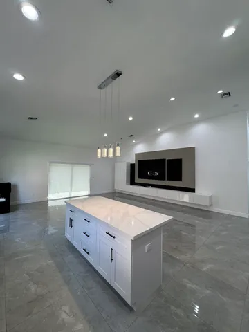 a large kitchen with stainless steel appliances a large counter top