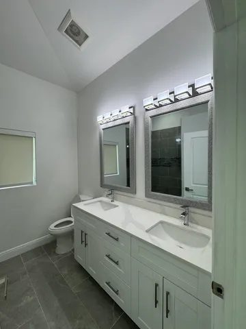 a bathroom with a double vanity sink and a mirror