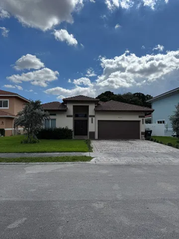 a front view of a house with a yard and a garage