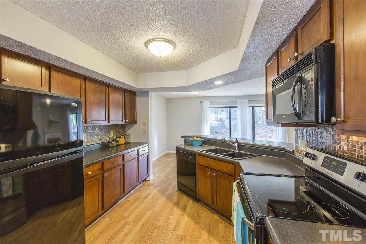 2451 Condor Court Raleigh, NC 27615 - Photo 14 of 23 a kitchen with stainless steel appliances granite countertop a sink stove and microwave