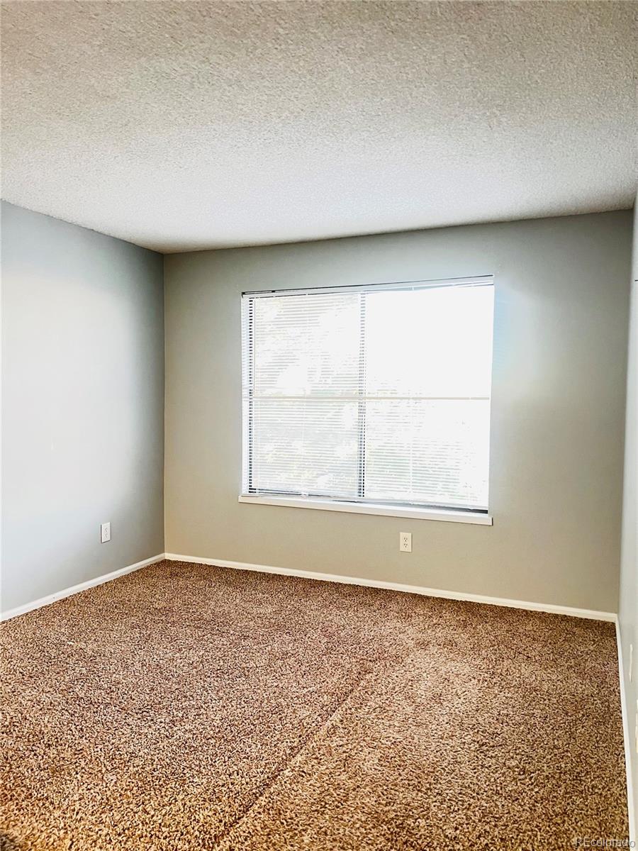 15911 East Dakota Place, Unit 301 Aurora, CO 80017 - Photo 11 of 18 an empty room with wooden floor and windows