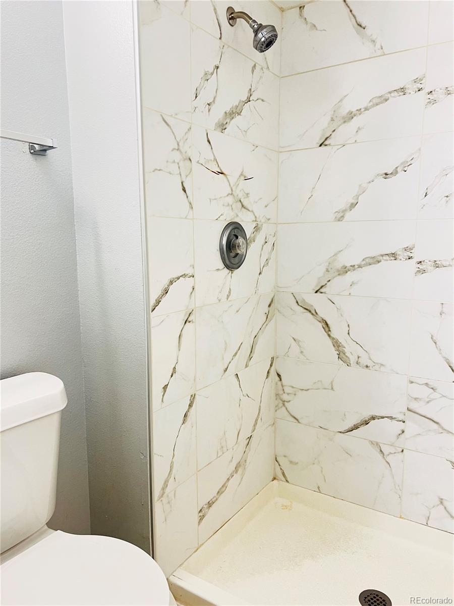 15911 East Dakota Place, Unit 301 Aurora, CO 80017 - Photo 14 of 18 a white toilet sitting next to a shower