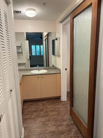 a view of kitchen with granite countertop cabinets and refrigerator