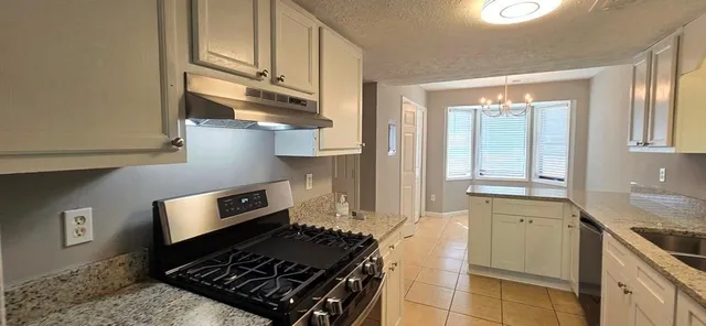 a kitchen with stainless steel appliances granite countertop a stove and a sink