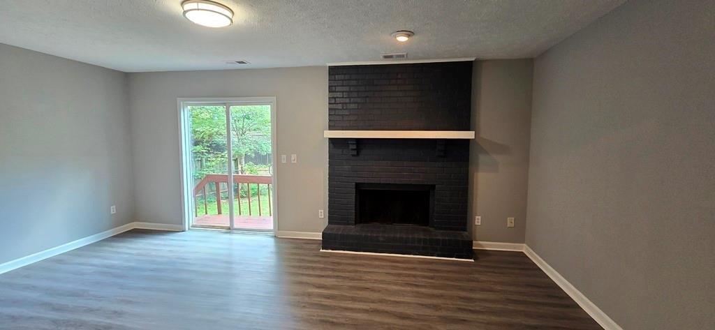 1020 Dassow Court Alpharetta, GA 30009 - Photo 7 of 18 an empty room with wooden floor fireplace and windows