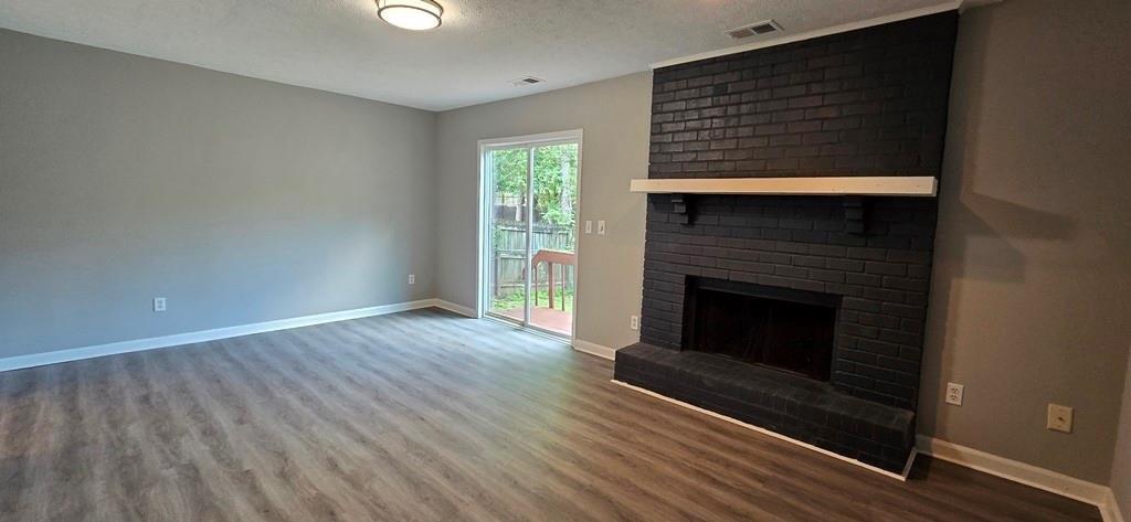 1020 Dassow Court Alpharetta, GA 30009 - Photo 8 of 18 a view of an empty room with wooden floor fireplace and a window