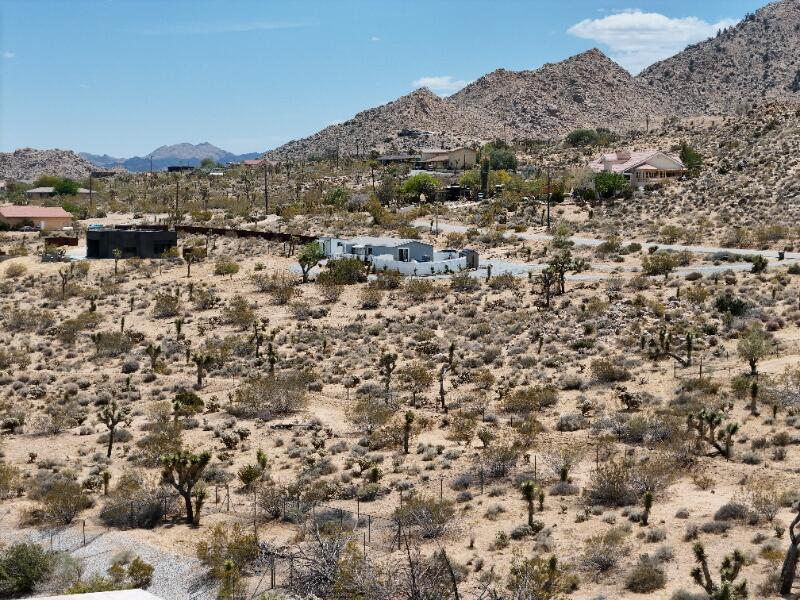 7608 Olympic Road Joshua Tree, CA 92252 - Photo 19 of 26 a view of a dry field with mountains in the background