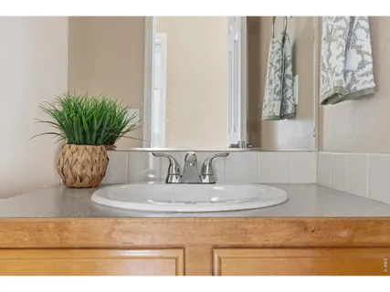 a bathroom with a granite countertop sink a mirror and vanity