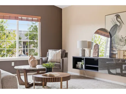 a living room with furniture a fireplace and a large window