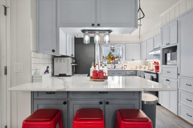 a kitchen with stainless steel appliances cabinets a dining table and chairs