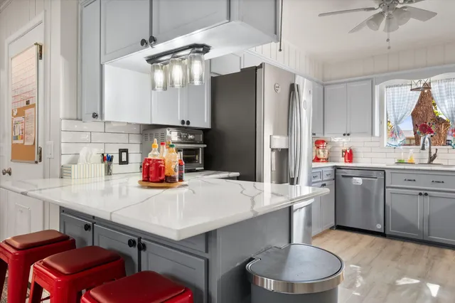 a kitchen with a sink a stove a refrigerator and cabinets
