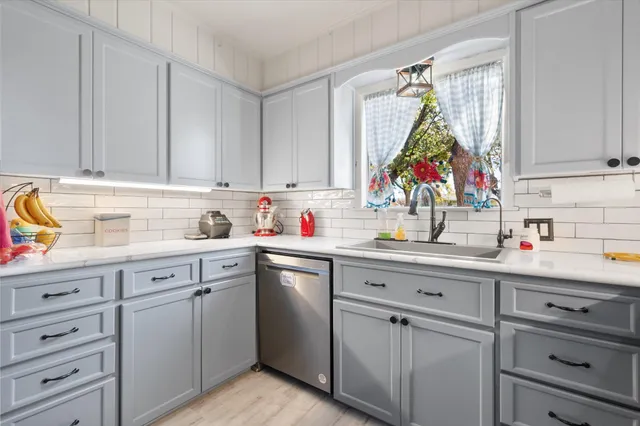 a kitchen with white cabinets and white appliances
