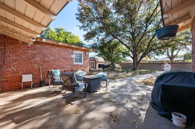 a view of a backyard with table and chairs and a barbeque