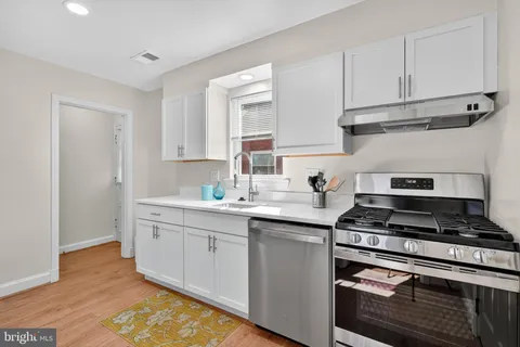 a kitchen with stainless steel appliances granite countertop a sink stove and cabinets