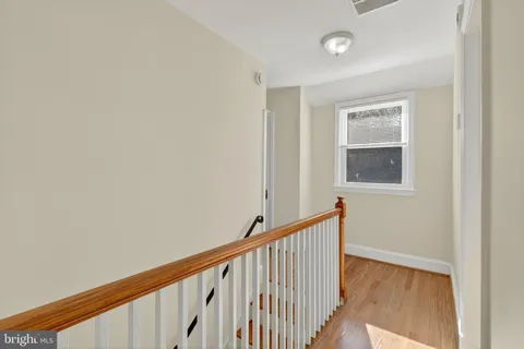 a view of a hallway with wooden floor and a window