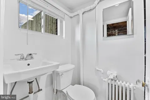 a bathroom with a sink mirror and toilet