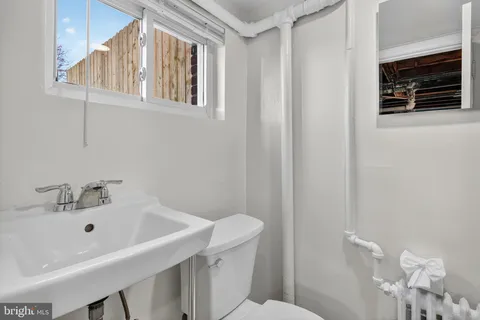 a bathroom with a sink a toilet and shower curtain