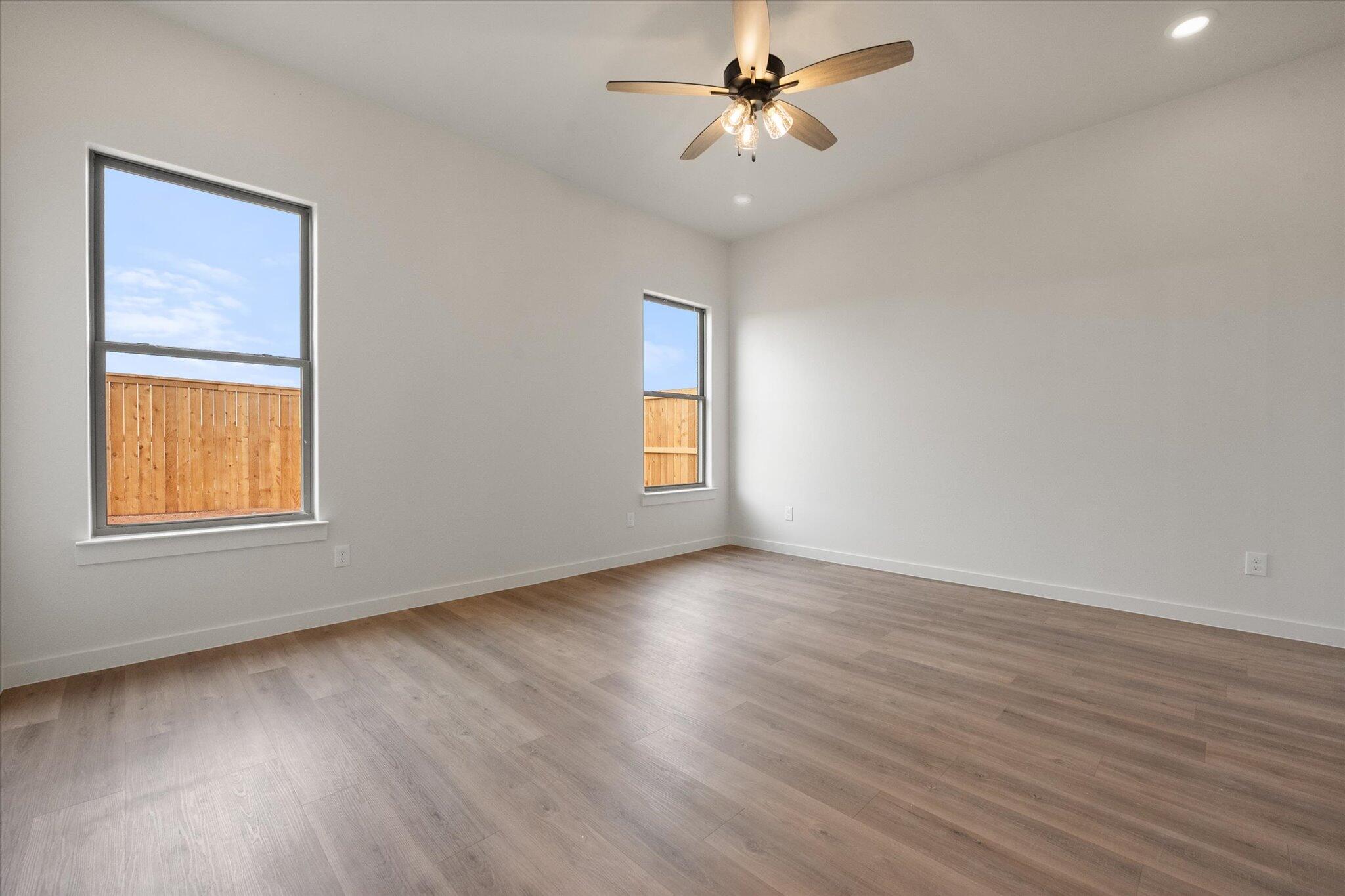 2901 Tractor Avenue Wolfforth, TX 79382 - Photo 12 of 25 a view of an empty room with a window and wooden floor