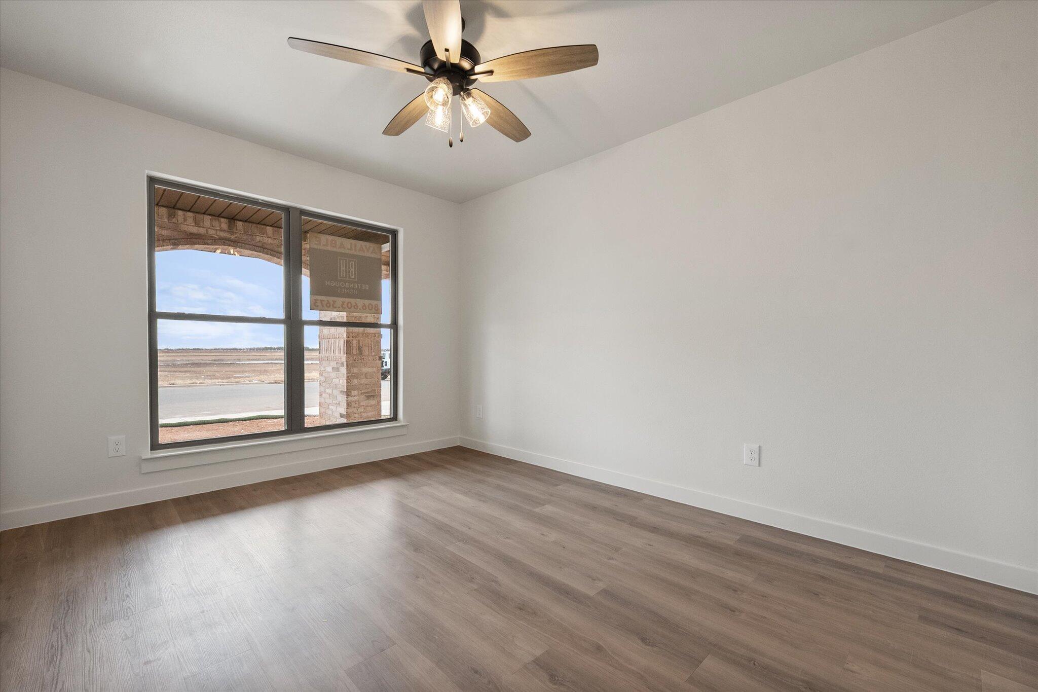 2901 Tractor Avenue Wolfforth, TX 79382 - Photo 20 of 25 an empty room with wooden floor fan and windows
