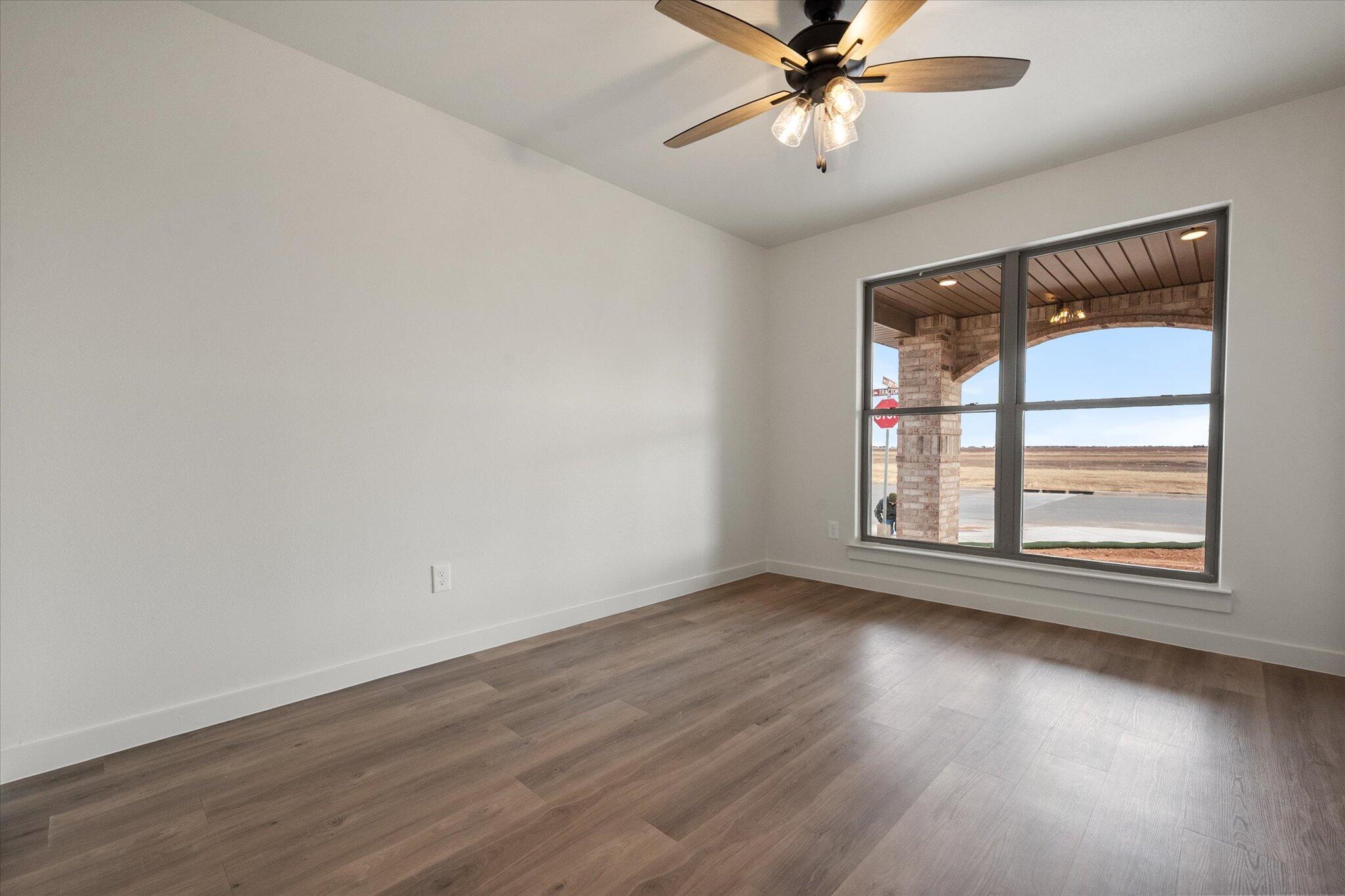 2901 Tractor Avenue Wolfforth, TX 79382 - Photo 21 of 25 a view of an empty room with wooden floor and a window