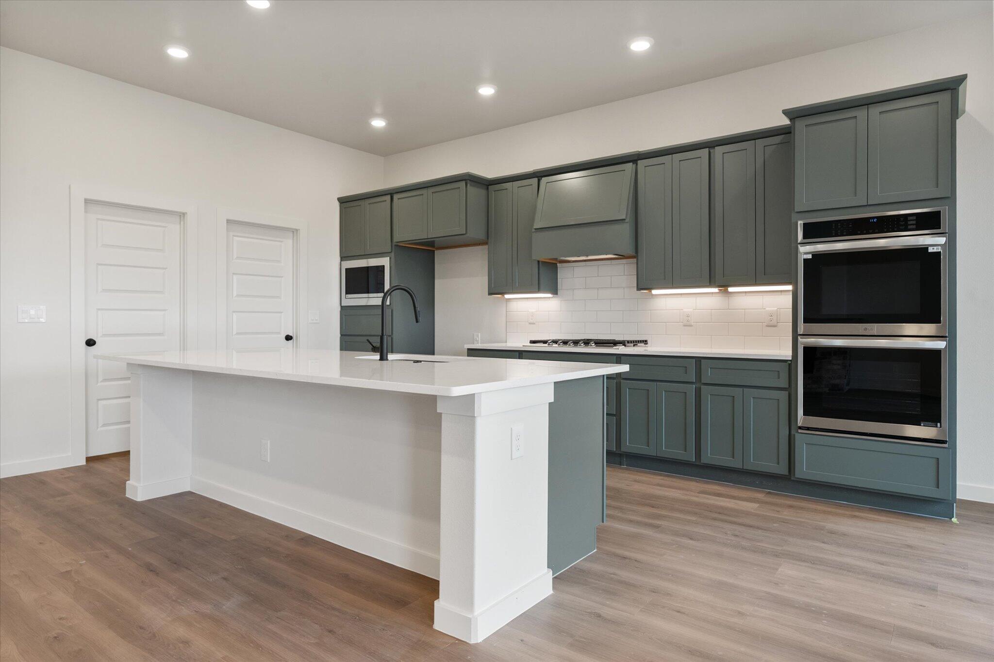 2901 Tractor Avenue Wolfforth, TX 79382 - Photo 7 of 25 a kitchen with stainless steel appliances kitchen island granite countertop a stove a sink and a microwave
