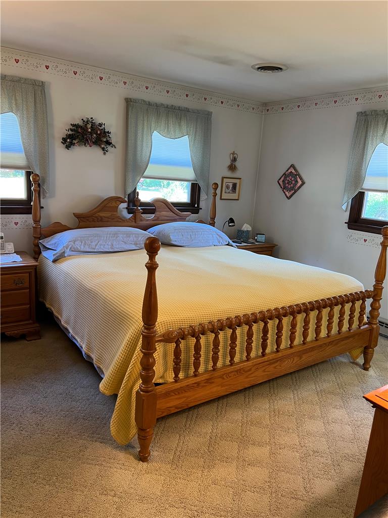 6830 Gun Club Road Coopersburg, PA 18036 - Photo 10 of 30 Comfortable bedroom with a traditional wooden bed frame and two sun-filled windows.