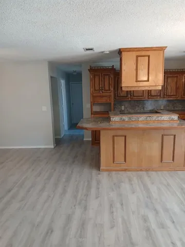 a view of kitchen with granite countertop window and wooden floor