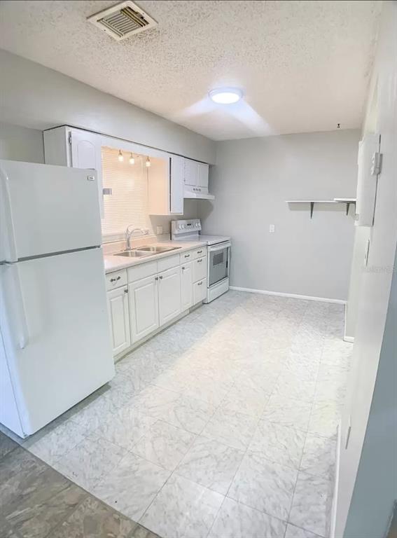 530 5th Avenue West, Unit C Palmetto, FL 34221 - Photo 12 of 27 a kitchen with white cabinets and white appliances