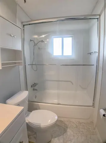 a bathroom with a toilet and a shower