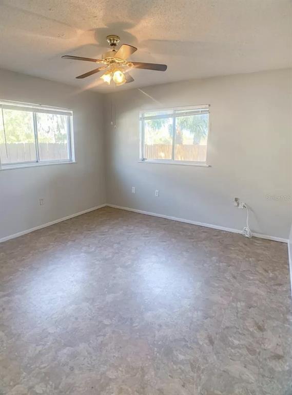 530 5th Avenue West, Unit C Palmetto, FL 34221 - Photo 19 of 27 an empty room with windows and chandelier fan