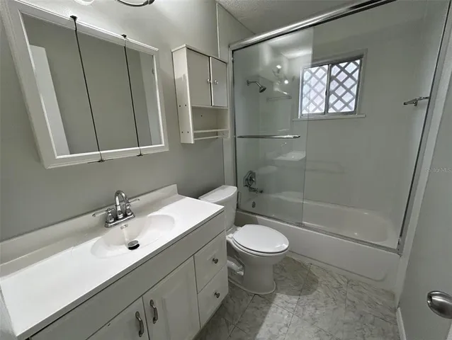 a bathroom with a sink toilet a mirror and shower