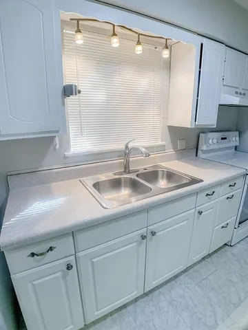 a close view of a sink and a mirror in a kitchen