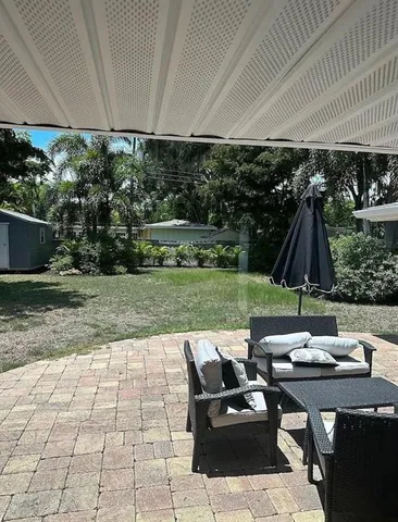 a view of a patio with table and chairs under an umbrella